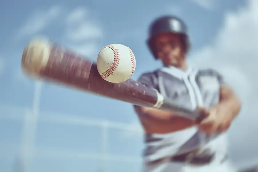 A baseball player swinging a bat at a ball after baseball and softball training classes at Darrah's All-Star Academy.