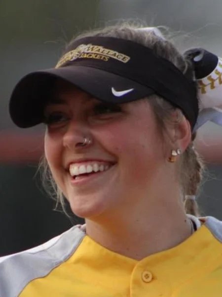 Headshot Photo of Hannah Welling in a softball hat smiling while playing a game.