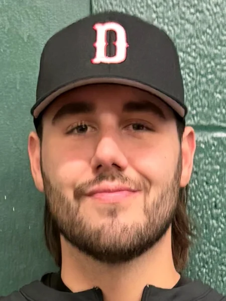 Headshot photo of Zach Rogers in a Darrah's baseball hat in front of a green wall.